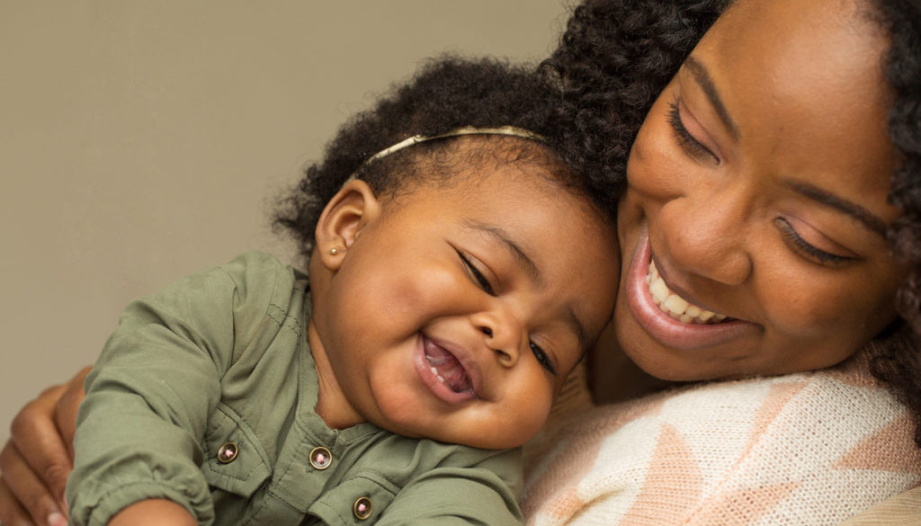 Happy African American mother and daughter playing.