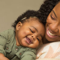 Happy African American mother and daughter playing.