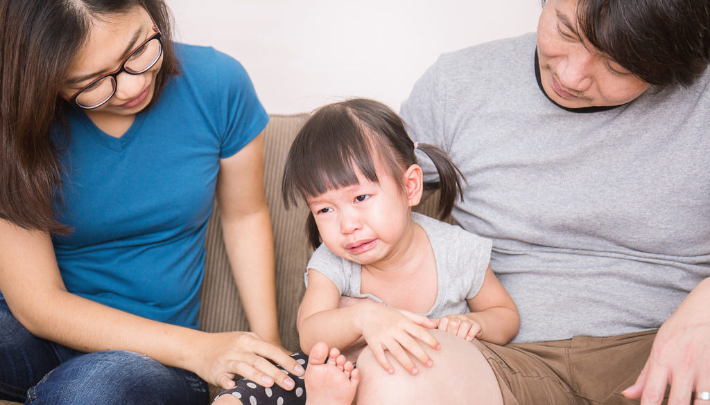 Parents calm crying girl portrait of parents embraces daughter