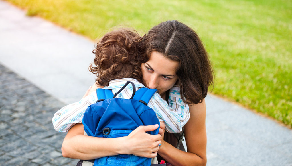 A Woman Is Hugging A Boy.